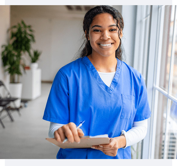 Smiling nurse holding a clipboard in a bright medical setting.